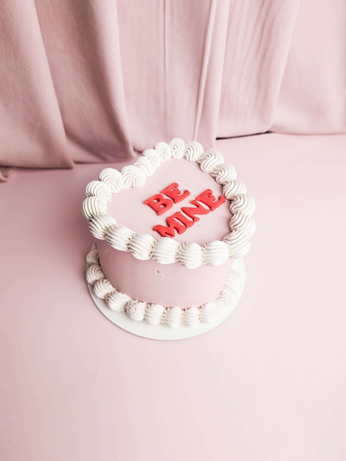 Light purple vintage heart cake with white cream decor and red caption  be mine